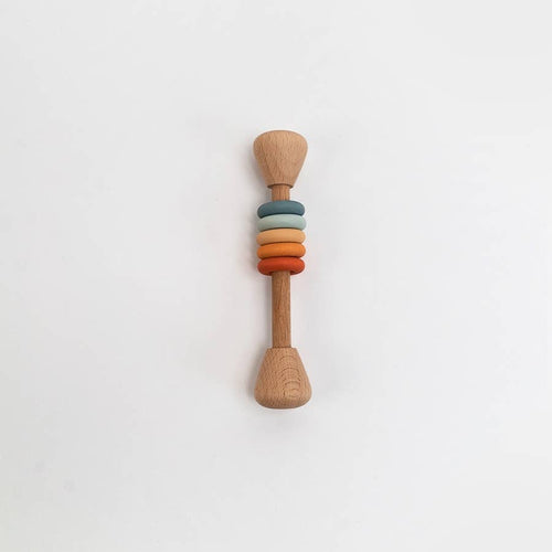 Wooden rattle with colorful rings on a white background
