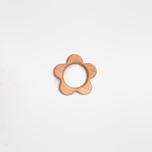 A small flower-shaped wooden teether or ring toy with a natural light wood finish, centered on a plain white background.