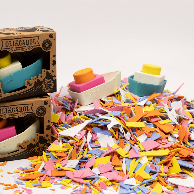 Colorful wooden toy boats with a 'Oli & Carol' box on a white background