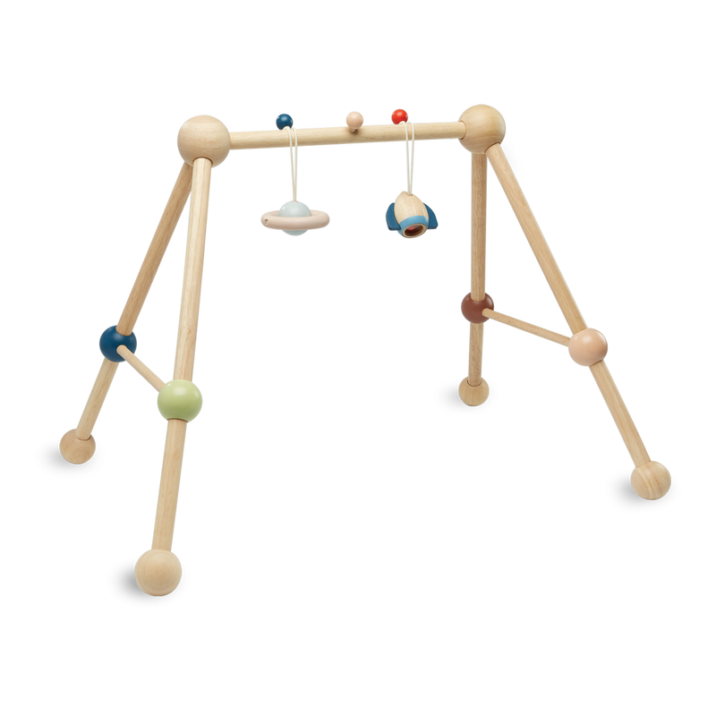Wooden baby gym with hanging toys on a white background
