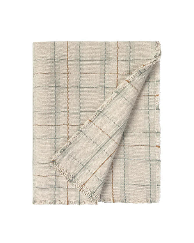 Folded checkered blanket with frayed edges on a white background