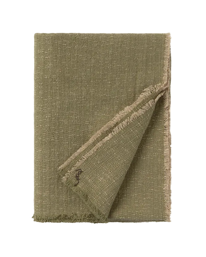 Green textured blanket with frayed edges on a white background
