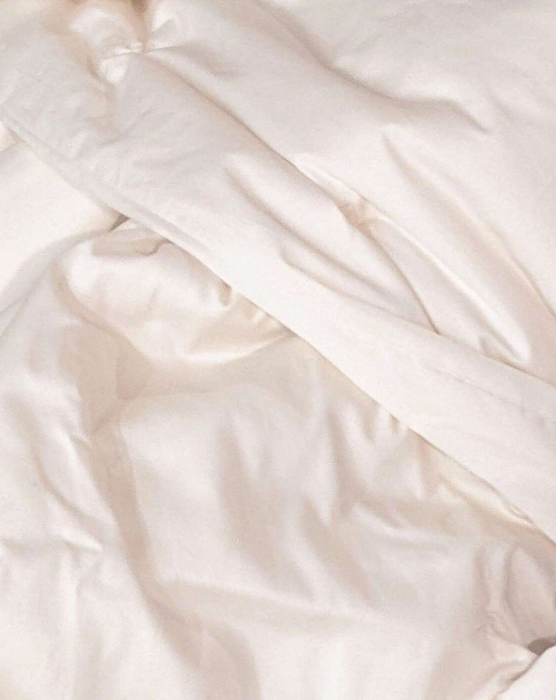 Close-up of white satin fabric with soft folds