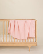 light pink organic cotton gauze swaddle on crib 