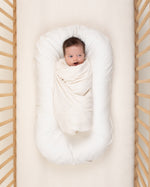 baby wrapped in undyed ivory organic cotton swaddle
